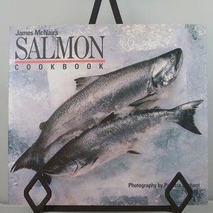 May include: A cookbook titled "James McNair's Salmon Cookbook" with a photo of two salmon on a blue and white background.