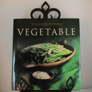 May include: A cookbook titled "Williams-Sonoma Vegetable" with a green background and a photo of sauteed asparagus on the cover.
