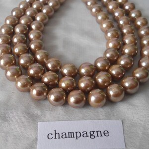 May include: A strand of champagne-colored pearls, with a label that reads "champagne".