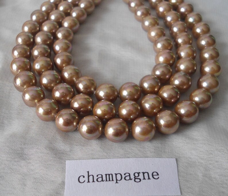 May include: A strand of champagne-colored pearls, with a label that reads "champagne".