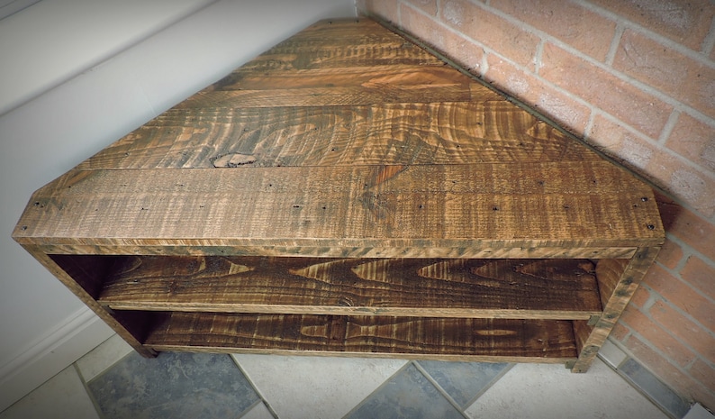 May include: A wooden corner shelf with two shelves. The shelf is made of reclaimed wood and has a rustic finish.