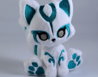 May include: White plush toy fox with teal embroidery details. The fox has a teal nose, eyes, and paw prints. The embroidery design features a stylized fox face with a swirl pattern.