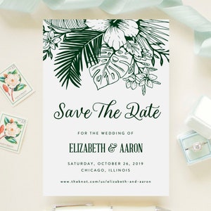 Puede incluir: Tarjeta de guardar la fecha con un tema tropical. La tarjeta presenta una ilustración verde y blanca de hojas de palma y flores. El texto en la tarjeta dice "Save the Date" para la boda de Elizabeth & Aaron, sábado 26 de octubre de 2019, Chicago, Illinois, www.theknot.com/us/elizabeth-and-aaron.