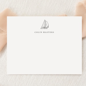 Könnte beinhalten: Eine weiße rechteckige Schreibwarenkarte mit einer schwarzen Strichzeichnung eines Segelboots, die oben zentriert ist, wobei der Name COLIN MASTERS in schwarzen Großbuchstaben direkt unter der Segelbootillustration auf der Karte gedruckt ist.
