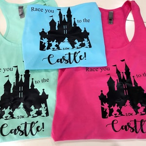 May include: Three tank tops with a black silhouette of Cinderella's castle and the text "Race you to the castle!" printed on them. The tank tops are in turquoise, light blue, and pink.