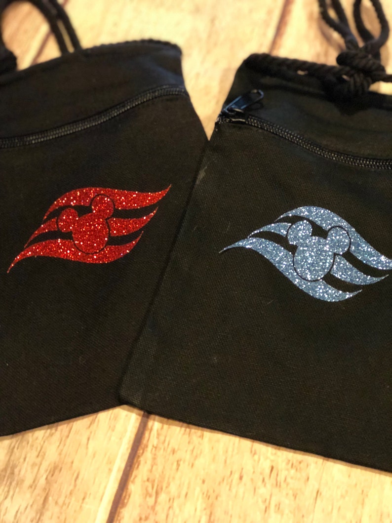 May include: Two black drawstring bags with a zipper closure. One bag has a red glitter Mickey Mouse head and the Disney Cruise Line logo. The other bag has a blue glitter Mickey Mouse head and the Disney Cruise Line logo.