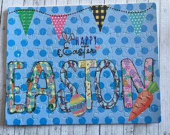 May include: A blue jigsaw puzzle with a Happy Easter message and the name Easton spelled out in colorful letters. The letters are decorated with Easter-themed patterns like carrots, butterflies, and eggs.