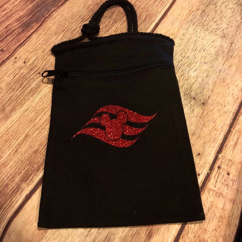 May include: Black drawstring bag with a zipper closure and a red glitter Mickey Mouse head on a red glitter wave design.
