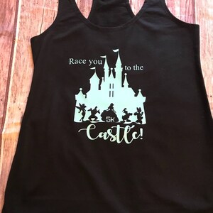 May include: Black tank top with a light blue graphic of Cinderella's castle and the text "Race you to the castle!" with a 5K logo.