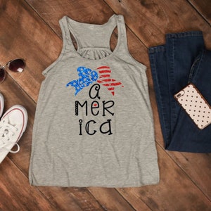 K&ouml;nnte beinhalten: Ein graues Tanktop mit einem rot-wei&szlig;-blauen Herzdesign und dem Text "a mer ica".