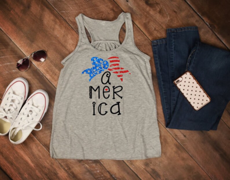 K&ouml;nnte beinhalten: Ein graues Tanktop mit einem rot-wei&szlig;-blauen Herzdesign und dem Text "a mer ica".