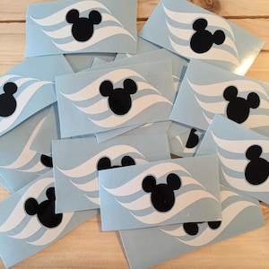 May include: A stack of blue and white Disney Cruise Line stickers featuring Mickey Mouse's silhouette and three white waves.
