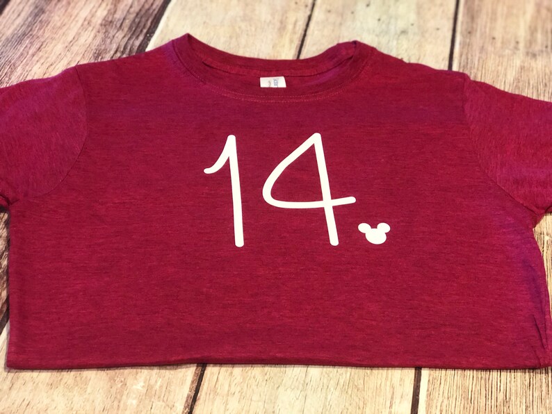 May include: Burgundy t-shirt with the number 14 and a white Mickey Mouse silhouette.