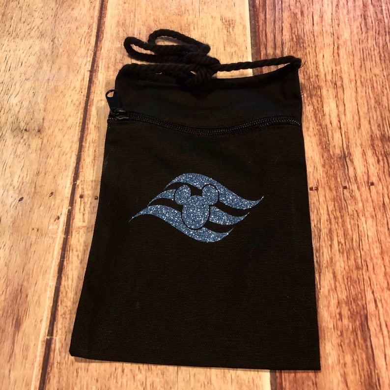 May include: Black drawstring bag with a zipper closure. The bag features a blue glitter Mickey Mouse head inside a blue glitter wave design.
