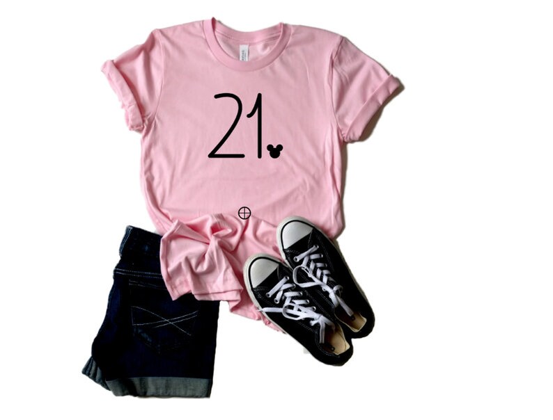 May include: Pink t-shirt with the number 21 and a small Mickey Mouse icon printed on the front.