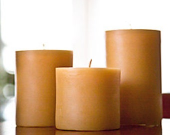 May include: Three natural beeswax candles of varying sizes, all in a light honey color.