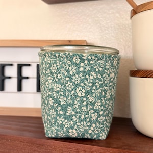 May include: A set of three ceramic mugs with a speckled, matte finish. Each mug is a different colour: light blue, cream, and grey. The mugs have a simple, modern design and a comfortable handle.