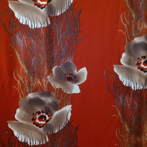 May include: A vibrant red fabric featuring a repeating floral pattern. The design showcases large, stylized flowers in shades of gray, white, and brown, with red and black centers. The flowers are set against a backdrop of vertical, textured lines.