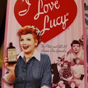 May include: DVD of "I Love Lucy" Season One, featuring a large red heart with the show's title. The cover includes images of the cast and the text "The Pilot and All 35 Season One Episodes."