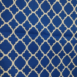 May include: Close-up of a blue fabric with a white quatrefoil pattern. The repeating design creates a geometric, symmetrical look. The fabric is likely used for home decor or apparel.