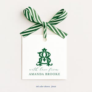 May include: A square white gift tag featuring a dark green monogram of the letters AB, the text with love from AMANDA BROOKE, and a green and white diagonal striped ribbon tied in a bow at the top. The text ink color shown is forest.
