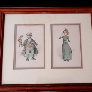 Può includere: Un set di due illustrazioni vintage incorniciate. L'illustrazione a sinistra raffigura un uomo con un cappotto e un cappello verdi che tiene un burattino. L'illustrazione a destra raffigura una donna con un vestito verde. Entrambe le illustrazioni sono in una cornice marrone.