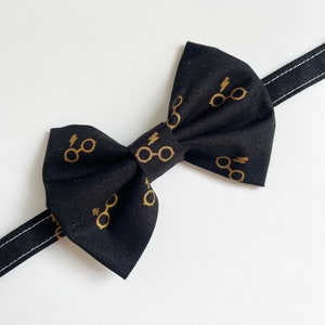 May include: Black bow tie with a gold lightning bolt and glasses pattern.