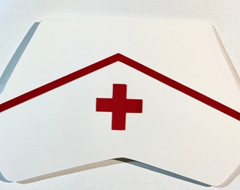 May include: White paper nurse's hat with a red trim and a red cross in the center.