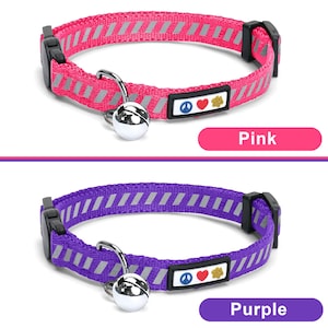 May include: Two cat collars with a bell and a peace sign, heart, and paw print charm. The collar on the top is pink with silver reflective stripes. The collar on the bottom is purple with silver reflective stripes.