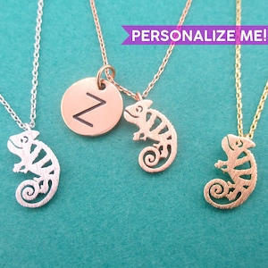 May include: Three necklaces with chameleon pendants. One is silver, one is rose gold with a round charm with the letter "Z", and one is gold. The text "PERSONALIZE ME!" is in a purple banner.
