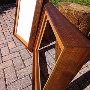 Pu&ograve; includere: Due cornici per foto in legno con finitura in legno naturale. Le cornici sono realizzate in diversi tipi di legno, una con una tinta pi&ugrave; scura e l'altra con una tinta pi&ugrave; chiara. Le cornici sono entrambe rettangolari e hanno un design semplice.