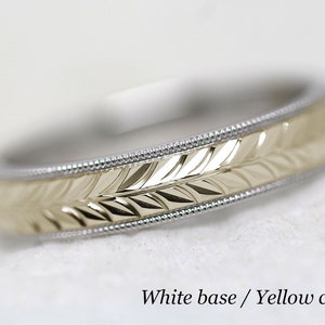 May include: A wedding band with a white gold base and a yellow gold center. The center band features a leaf design.