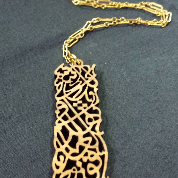 Olivewood Arabic Calligraphy pendant with quote by  Palestinian writer Ghassan Kanfani "There is something for you on this Earth, so get up