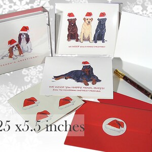 May include: A set of Christmas cards featuring dogs wearing Santa hats. The cards are 4.25 by 5.5 inches and come with red envelopes. The cards feature different breeds of dogs, including a Cavalier King Charles Spaniel, a Labrador Retriever, and a Gordon Setter.