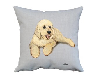 May include: A light gray throw pillow with a white dog with brown eyes and a pink tongue sticking out. The dog is lying down with its head turned to the side. The pillow has a zipper on the bottom.