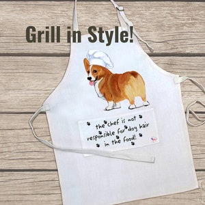 May include: White cotton apron with a pocket featuring a cartoon image of a corgi wearing a chef's hat. The text on the pocket reads "the chef is not responsible for dog hair in the food!"
