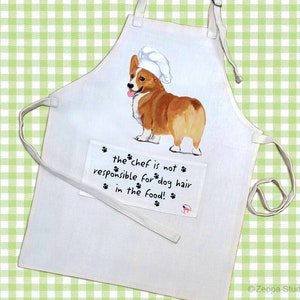 May include: White cotton apron with a pocket featuring a cartoon image of a corgi wearing a chef's hat. The text on the pocket reads "the chef is not responsible for dog hair in the food!"