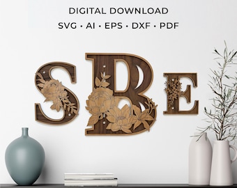 May include: A digital download laser cut file featuring the letters S, B, and E in a dark wood finish. Each letter is decorated with intricate, layered floral designs. The text LASER CUT FILE, DIGITAL DOWNLOAD, SVG, AI, EPS, DXF, PDF is included.