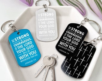May include: Keychains in blue, silver, and black, each with a dog tag shape and a silver keyring. The tags feature the text "BE STRONG & COURAGEOUS. THE LORD YOUR GOD WILL BE WITH YOU WHEREVER YOU GO. JOSHUA 1:9" in white.
