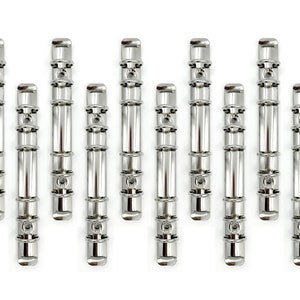May include: Ten silver metal binder rings, each with four holes, arranged in a row on a white background.