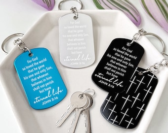 May include: Keychains in blue, silver, and black, each featuring the text "For God so loved the world...eternal life, John 3:16." The black keychain has a cross pattern. The keychains are attached to silver keyrings.