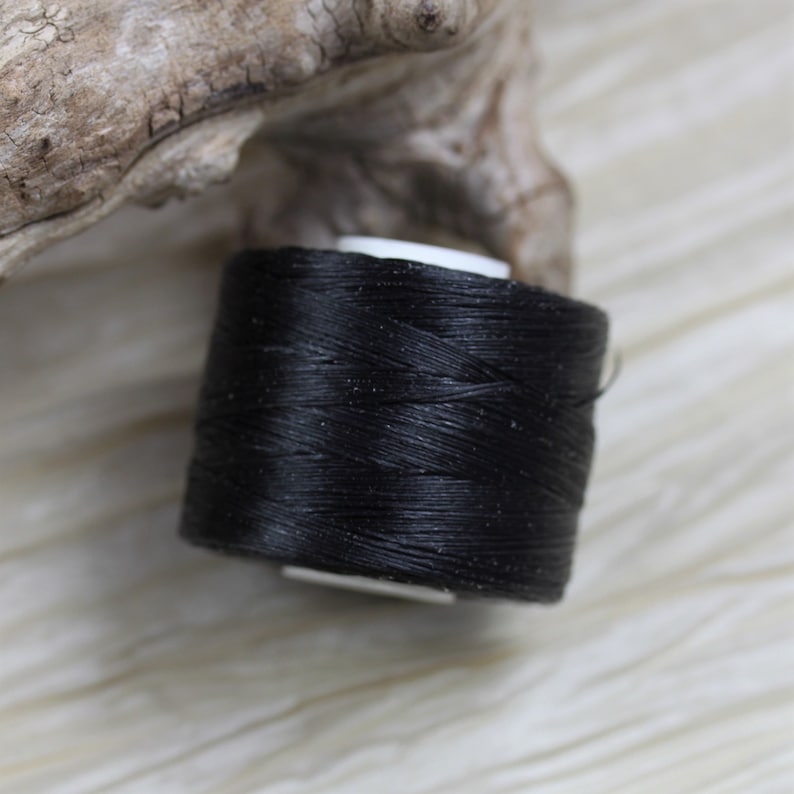 Puede incluir: Una bobina de hilo negro para coser o hacer manualidades.