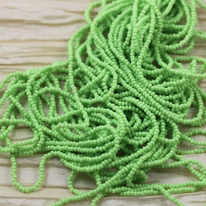 May include: A large pile of light green seed beads. The beads are small and round, and they are perfect for making jewelry or other crafts.