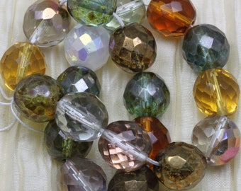 May include: A strand of faceted glass beads in various colors, including green, brown, gold, and clear. The beads are all approximately the same size and have a faceted, iridescent finish.