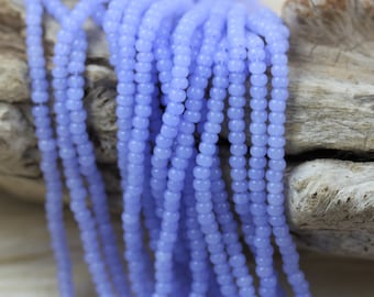 May include: A strand of light blue glass beads. The beads are round and have a matte finish.