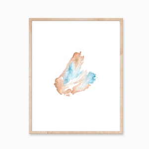 May include: A framed watercolor painting of a blue and orange abstract shape on a white background.
