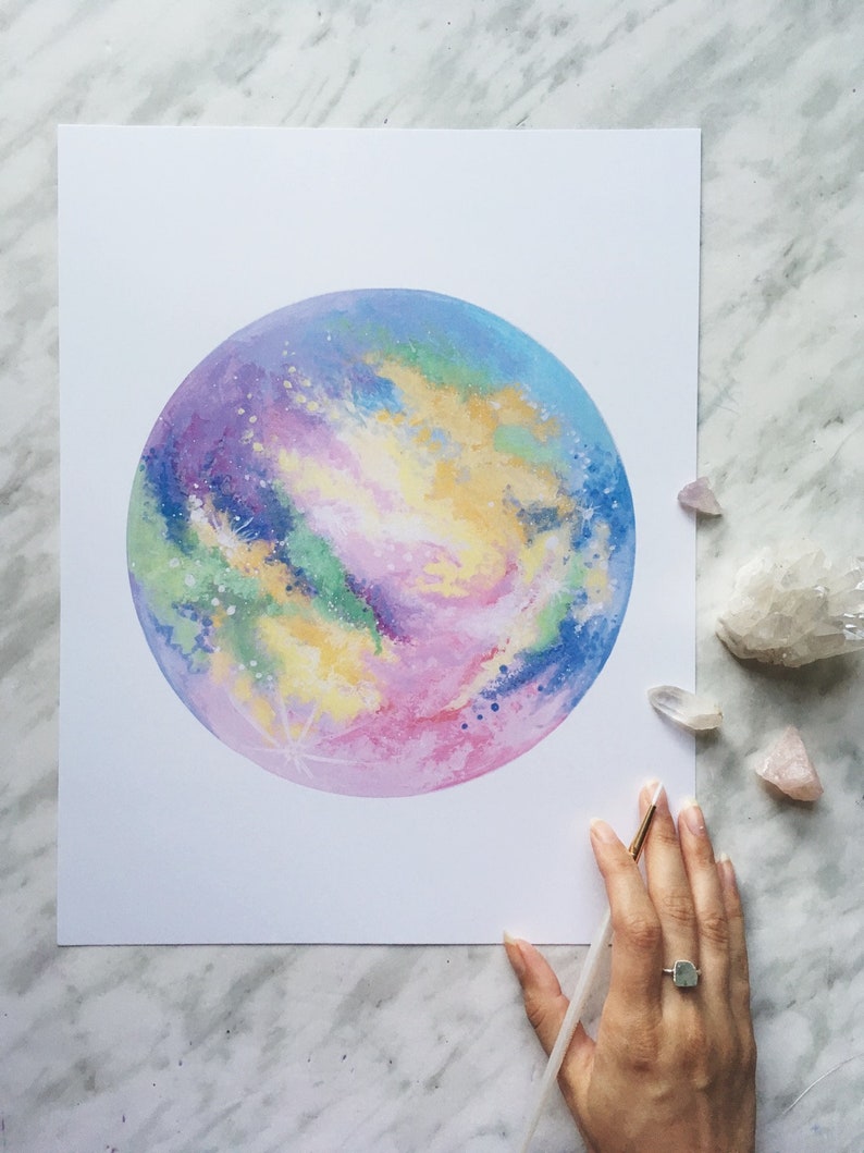 Pu&ograve; includere: Un dipinto ad acquerello di una galassia colorata con sfumature di rosa, viola, blu, verde e giallo. La galassia &egrave; dipinta in una forma circolare, che ricorda un pianeta.