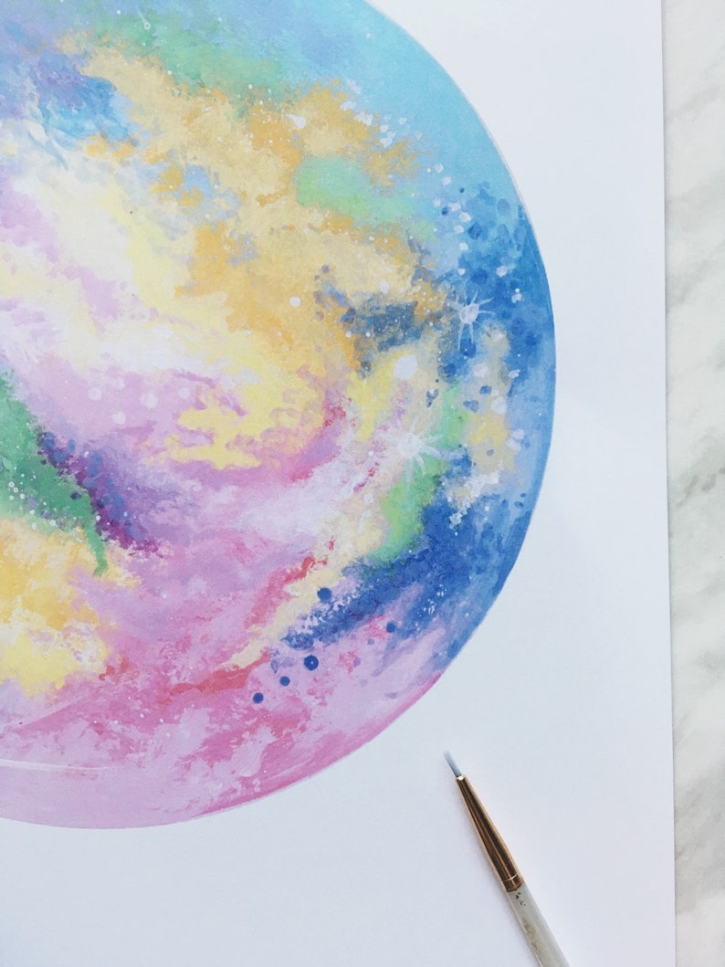 Pu&ograve; includere: Un dipinto ad acquerello di una galassia colorata con sfumature di blu, rosa, giallo e verde. La galassia &egrave; dipinta in forma circolare e ha uno sfondo bianco.