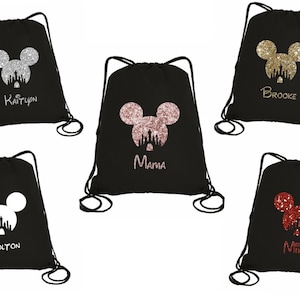 May include: Black drawstring bags with a Mickey Mouse head design in silver, rose gold, gold, white, and red glitter. Each bag has a name printed below the design: Kaitlyn, Mama, Brooke, Colton, and Mike.