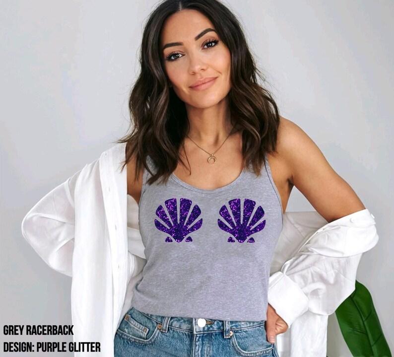 May include: A grey racerback tank top with a purple glitter seashell design. The tank top is worn with blue jeans and a white button-down shirt. The text on the bottom of the image reads: GREY RACERBACK, DESIGN: PURPLE GLITTER.